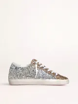 Zapatillas Golden Goose modelo Super-Star, cubiertas de glitter plateado y dorado.