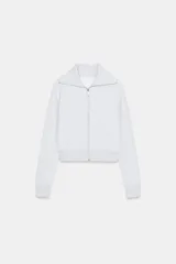 Chaqueta de felpa en color gris jaspeado, con cuello solapa, cierre frontal con cremallera metálica, manga larga con puños y bolsillos delanteros.