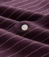 Camisa de manga corta con cuello solapa, cierre frontal de botones y diseño a rayas verticales. Confeccionada en algodón con textura.