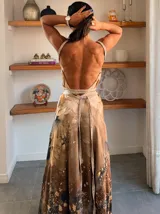 Vestido largo verde con diseño estampado tipo tie-dye y detalles dorados, de corte fluido, un solo hombro y diseño amplio.