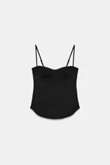 Top negro de estilo corsetero con escote corazón, copas definidas y tirantes finos ajustables. El bajo es redondeado.