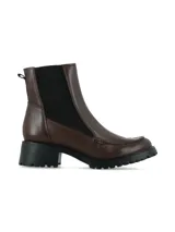 Bota tipo Chelsea de cuero color marrón, con paneles elásticos laterales en color negro, costura decorativa en la puntera y suela track dentada con taco cuadrado.