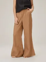 Pantalón de lino color tostado, de corte amplio y fluido con piernas acampanadas.
