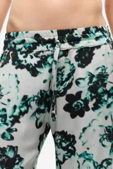 Pantalón de tela fluida con estampado floral en tonos gris, verde y negro, con cintura elástica y corte recto.