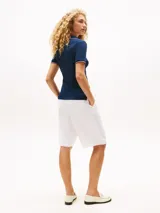 Chomba azul marino de algodón elástico, corte slim, con cuello polo con escote en V y mangas cortas con ribetes distintivos en blanco y rojo. Logo de Tommy Hilfiger bordado en el pecho.