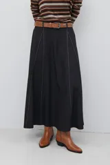 Falda larga de jean color azul oscuro con corte evasé y costuras con pespuntes a contratono. Presenta una cintura elástica para mayor comodidad.