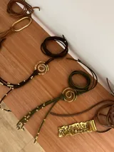 Gargantilla de gamuza marrón con dije de espiral dorado y cuentas de bronce.