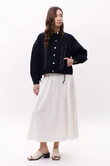 Sandalia de cuero vacuno color marrón oscuro, con faja ancha y punta cuadrada. Presenta talón abierto y taco bajo y grueso.