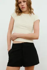 Bermudas de tiro medio color marrón con bolsillos en delantero y falsos bolsillos con solapa en espalda, de corte estructurado y cierre frontal con cremallera y ganchos metálicos.