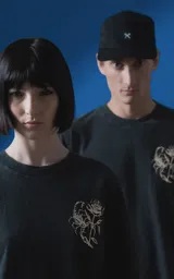 Remera de algodón premium con efecto nevado, corte oversize y cuello redondo. Presenta una estampa gráfica en la espalda con motivos de escorpión, rosa y tipografía en color crema.