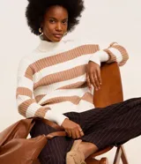 Suéter de punto pesado con cuello alto y mangas largas. Diseño a rayas horizontales en blanco y negro con textura acanalada.