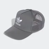 Gorra tipo trucker de cinco paneles en color gris, con paneles traseros y laterales de malla transpirable. Presenta el logo del Trifolio de Adidas bordado en blanco en la parte frontal, visera precurvada y cierre trasero ajustable a presión.