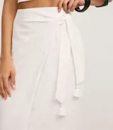 Pollera midi recta color blanco, de laise con bordados geométricos y lazo en la cintura.