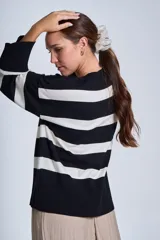 Sweater Bremer con cuello redondo y mangas largas ligeramente amplias. Diseño a rayas horizontales en color crudo y negro.