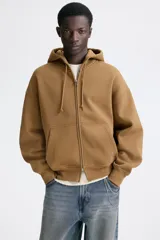 Campera con capucha H&M de corte oversized, color marrón, con cierre frontal y bolsillos tipo canguro.