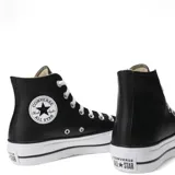 Championes de caña alta Converse modelo Chuck Taylor Lift, con capellada de cuero sintético negro, cordones blancos y suela de plataforma de goma blanca con puntera reforzada.