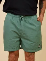 Short de algodón color verde, con cintura elástica y cordón ajustable. Presenta bolsillos laterales y un pequeño parche decorativo en la parte inferior.
