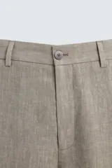 Pantalón de corte straight relaxed fit confeccionado en tejido de lino con efecto lavado. Presenta cierre frontal con cremallera y botón, bolsillos laterales y bolsillos traseros de vivo.