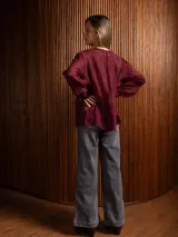 Blusa de tela liviana color crudo, con bordados florales tono sobre tono, escote en V con detalle de puntilla central, mangas largas con volumen y puños camiseros.