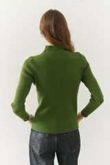 Polera de tejido morley color azul, con cuello alto y mangas largas, de corte ajustado al cuerpo.