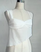 Top blanco de microtul con breteles finos y corte asimétrico.