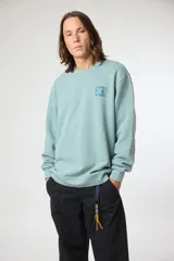 Buzo de cuello redondo color verde agua, con diseño de estampa pequeña en el pecho que incluye una cruz y caracteres japoneses.