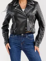 Campera estilo motoquera de símil cuero negro, con solapas amplias y detalles de tachas metálicas en solapas, hombros y mangas. Presenta cierre frontal cruzado, bolsillos con cierre y trabillas en el ruedo.