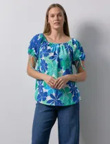 Blusa de seda fría con estampado floral en tonos azules y verdes. Cuello redondo con frunce y mangas cortas amplias con terminación fruncida.