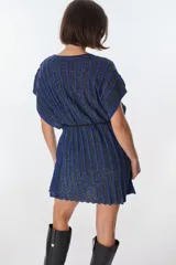 Vestido corto de tejido de punto con rayas verticales en tonos marrón y beige/dorado, con escote en V y tiras finas que se anudan al cuello.