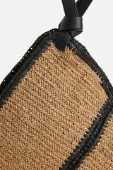 Bolso shopper tejido en tono camel con detalles de costuras y asas de hombro en color negro, de diseño estructurado.