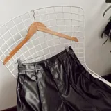 Pantalón de ecocuero negro, de corte recto y tiro alto.