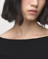 Remera negra de manga larga con cuello barco, confeccionada en tejido elástico y entallado.