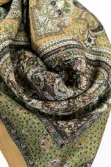 Pañuelo de forma cuadrada con estampado paisley en tonos verdes, tostados y marrones, con bordes en tono mostaza.