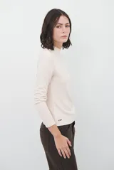 Polera de manga larga con cuello alto, confeccionada en tejido suave de viscosa con corte relajado y detalle de costura tipo collareta en la espalda.