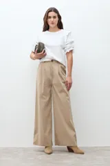 Remera blanca de algodón con cuello redondo y mangas cortas abullonadas con volados y detalles calados.