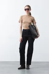 Pantalón negro de fit recto confeccionado en cotton spandex, con costuras visibles que recorren la pierna y bordados decorativos en los bolsillos y ruedo.