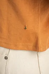 Remera color camel, de corte al cuerpo, manga corta con vuelta y cuello redondo.