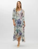 Conjunto compuesto por un vestido midi de gasa con estampado floral en tonos violeta, azul y crema, con escote en V, tirantes anchos y ruedo asimétrico con volados. Incluye una chaqueta corta tipo torera de mangas 3/4 confeccionada en la misma tela. Posee forro interno a tono.