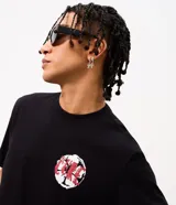 Remera de algodón color negro con cuello redondo y manga corta. Presenta una estampa en la espalda con la imagen de la banda The Cure y efecto de pintura chorreada, junto con el logo de la banda en color rojo.