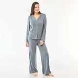 Pijama de dos piezas compuesto por una camisa de manga larga con botones frontales, cuello solapa y bolsillo en el pecho, y un pantalón de corte recto y holgado. Ambas prendas presentan un diseño liso en color gris con detalles de ribetes en contraste.