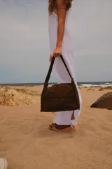 Cartera de hombro tipo hobo, confeccionada en cuero con textura de reptil. Presenta un diseño estructurado con costuras visibles y cierre superior.