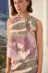 Top sin mangas de lino 100%, con diseño estampado multicolor en tonos rosado, verde y beige. Presenta cuello redondo y una cartera asimétrica con botones de madera frontales.