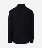 Camisa de manga larga confeccionada en sarga de algodón color verde menta, con cuello inglés y cierre frontal de botones negros. Presenta dos bolsillos de parche con solapa en el pecho y puños con botones.