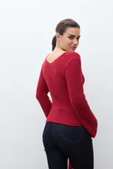 Sweater de punto acanalado color rojo, con escote en V, mangas largas acampanadas y lazo ajustable en la cintura.