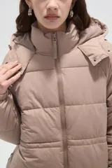 Campera puffer de corte holgado, color beige, con capucha desmontable, cierre frontal y puños elásticos.