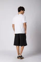 Bermuda sastrera baggy de color negro con diseño de rayas diplomáticas finas blancas. Cuenta con bolsillos laterales y presillas para cinturón.