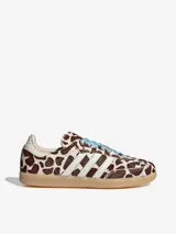 Championes Adidas Samba OG con diseño de estampado animal print de vaca en tonos marrón y blanco. Presenta las icónicas tres bandas laterales en blanco, cordones en color celeste y suela de goma natural.