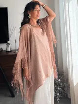 Poncho o chal negro de tejido abierto y transparente, con pequeños detalles brillantes incrustados y flecos largos en los bordes.