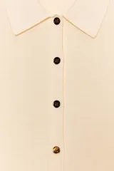 Chaqueta de punto gris oscuro, de manga larga, con cuello solapa y cierre frontal de botones dorados.