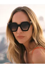 Lentes de sol Tiwi modelo Hexagon II, con montura geométrica negra y detalles en color cobre. Lentes color borgoña con filtro degradado.